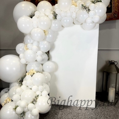 Белая фотозона из латексных шаров с декоративными цветами и баннером фото