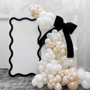 Контрастная бело-черная фотозона из шаров с бантом и баннером в рамке фото